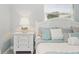 Well-lit bedroom with white bedside table, lamp, and coastal-themed bedding at 703 Valencia Shores Dr, Winter Garden, FL 34787