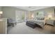 Bright bedroom with French doors, plush carpet, ceiling fan and gray bench at the foot of the bed at 703 Valencia Shores Dr, Winter Garden, FL 34787