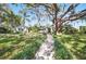 Charming home with a meticulously manicured lawn, complemented by a beautiful walkway and mature trees at 703 Valencia Shores Dr, Winter Garden, FL 34787
