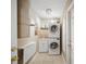 Functional laundry room with stacked washer and dryer, sink, and folding table at 703 Valencia Shores Dr, Winter Garden, FL 34787