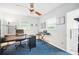 Home office featuring desk, keyboard, ceiling fan, and a bright blue carpet at 703 Valencia Shores Dr, Winter Garden, FL 34787