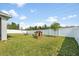 Spacious backyard with a white fence and a playhouse, ideal for Gathering fun and outdoor activities at 737 Hyperion Dr, Debary, FL 32713