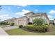 Beautiful home exterior featuring a beige garage door, paver driveway, and lush landscaping at 7928 Hanson Bay Pl, Kissimmee, FL 34747