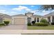 Charming single-story home with a paver driveway, tan garage door, and well-manicured landscaping at 7928 Hanson Bay Pl, Kissimmee, FL 34747