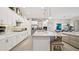 Modern kitchen features white cabinets, stainless appliances, a large island with bar seating, and opens to the dining area at 7928 Hanson Bay Pl, Kissimmee, FL 34747