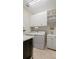 Bright laundry room with white washer, dryer, cabinets, and sink at 7928 Hanson Bay Pl, Kissimmee, FL 34747