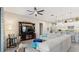 Cozy living room has a large sectional, ceiling fan, and an open flow into the kitchen and dining area at 7928 Hanson Bay Pl, Kissimmee, FL 34747