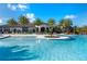 The community pool has a central island with palm trees, lounge chairs and covered eating area at 7928 Hanson Bay Pl, Kissimmee, FL 34747