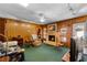 Comfortable living room featuring a brick fireplace, wood paneling, and access to the backyard, great for Gathering gatherings at 812 Arlington Blvd, Altamonte Springs, FL 32701