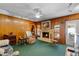 Spacious living room featuring a brick fireplace, wood paneling, and ample seating, ideal for relaxing and entertaining at 812 Arlington Blvd, Altamonte Springs, FL 32701