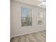 Bedroom featuring light-colored walls, wood-look floors, and two windows at 911 N Orange Ave # 447, Orlando, FL 32801