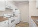A kitchen view features white cabinets and appliances, plus wood-look floors at 911 N Orange Ave # 447, Orlando, FL 32801
