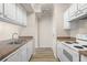 Galley kitchen view features stainless steel sink, white cabinets and appliances at 911 N Orange Ave # 447, Orlando, FL 32801