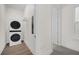 Functional laundry room with stacked washer and dryer, plus convenient shelving at 927 City Walk Ln, Oviedo, FL 32765