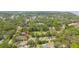 Aerial view of a residential area with homes and lush trees, plus a pond and a parking area at 106 Waterwood Dr, Yalaha, FL 34797