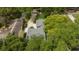 Aerial view showcasing the property's roof, driveway, and surrounding mature trees at 106 Waterwood Dr, Yalaha, FL 34797