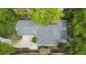 An aerial view shows a home with a gray roof, a driveway, and mature landscaping at 106 Waterwood Dr, Yalaha, FL 34797