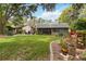 Scenic backyard with a well-kept lawn, mature trees, and charming landscaping at 106 Waterwood Dr, Yalaha, FL 34797