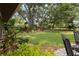 Lush backyard featuring mature trees, a well-maintained lawn, and a seating area at 106 Waterwood Dr, Yalaha, FL 34797