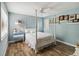 Serene bedroom with a four poster bed, wood floors, and blue painted walls at 106 Waterwood Dr, Yalaha, FL 34797