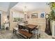 Formal dining room features rustic table, bench seating, chandelier, and natural light from a large window at 106 Waterwood Dr, Yalaha, FL 34797