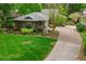 Aerial view of charming home featuring lush green lawn, mature trees and a paved driveway at 106 Waterwood Dr, Yalaha, FL 34797