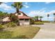 Club Waterwood building exhibiting its unique architecture, landscaping, and charming red tile roof on a sunny day at 106 Waterwood Dr, Yalaha, FL 34797