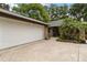 Exterior showcasing the garage with brick accents, a paved walkway, and lush tropical landscaping at 106 Waterwood Dr, Yalaha, FL 34797