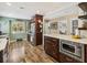 Well-lit kitchen features stainless steel appliances, custom cabinets, and wood flooring at 106 Waterwood Dr, Yalaha, FL 34797