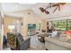 Comfortable living room featuring high ceilings, ceiling fans, and a sliding glass door to a screened-in porch at 106 Waterwood Dr, Yalaha, FL 34797