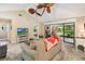 Open-concept living room boasts high ceilings, fan, and sliding glass doors opening to a screened-in lanai at 106 Waterwood Dr, Yalaha, FL 34797