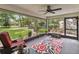 Relaxing screened porch with outdoor seating and a serene view of the beautifully landscaped backyard at 106 Waterwood Dr, Yalaha, FL 34797