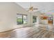 Bright bedroom featuring wood-look laminate floors, large windows, and closet with mirror doors at 1072 Weaver Dr, Oviedo, FL 32765