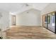 Spacious living room with wood-look laminate floors, fireplace, and sliding glass door to the outdoors at 1072 Weaver Dr, Oviedo, FL 32765