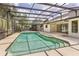 A screened in pool area with an outdoor spa and a house with sliding glass doors that lead to the lanai at 1072 Weaver Dr, Oviedo, FL 32765