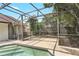 A screened in pool area with trees and a house with sliding glass doors that lead to the lanai at 1072 Weaver Dr, Oviedo, FL 32765