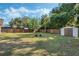 Spacious backyard with lush greenery, a storage shed, and privacy fence, perfect for outdoor activities at 1101 S Thompson Ave, Deland, FL 32720