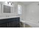 Modern bathroom with a sleek vanity, ample storage, and a tiled tub with shower combination at 1101 S Thompson Ave, Deland, FL 32720