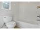 Bright and clean bathroom featuring a classic white tub, toilet, and tiled walls at 1101 S Thompson Ave, Deland, FL 32720