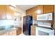 Well-equipped kitchen with wooden cabinets, granite countertops, and modern stainless steel appliances at 1140 S Orlando Ave # F-3, Maitland, FL 32751