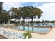 Community pool overlooks the lake with blue lounge chairs and mature trees at 1140 S Orlando Ave # F-3, Maitland, FL 32751
