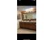 The bathroom features double sinks with granite countertops and dark wood cabinetry with a big mirror at 12544 Floridays Resort Dr # 102, Orlando, FL 32821