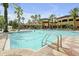 Resort-style pool surrounded by lush palm trees, offering a relaxing oasis for residents and guests at 12544 Floridays Resort Dr # 102, Orlando, FL 32821