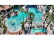 Aerial view of a vibrant resort pool area with palm trees, lounge chairs and water features at 12544 Floridays Resort Dr # 102, Orlando, FL 32821
