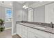 Bright bathroom featuring double sinks, granite counters, and neutral wall color at 13628 Abberwick Dr, Orlando, FL 32832