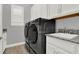 Well-organized laundry room features modern washer and dryer units, cabinets, and granite countertops at 13628 Abberwick Dr, Orlando, FL 32832