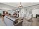 Bright living room with open floor plan, a leather sofa, wingback chairs, and stylish lighting fixtures at 13628 Abberwick Dr, Orlando, FL 32832