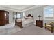 Spacious main bedroom with dark wood furniture, plush carpet, and outside balcony access at 13628 Abberwick Dr, Orlando, FL 32832
