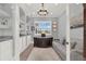 Well-lit home office featuring custom built-ins, large desk, comfortable couch, and neutral color palette at 13628 Abberwick Dr, Orlando, FL 32832