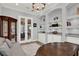 Well-lit home office featuring custom built-ins, glass display cabinet and a large wooden desk at 13628 Abberwick Dr, Orlando, FL 32832